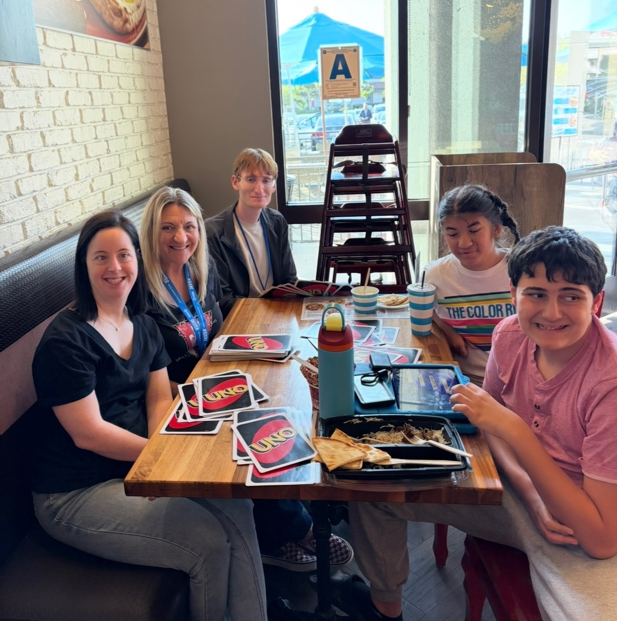 Group playing UNO card game together at a restaurant
